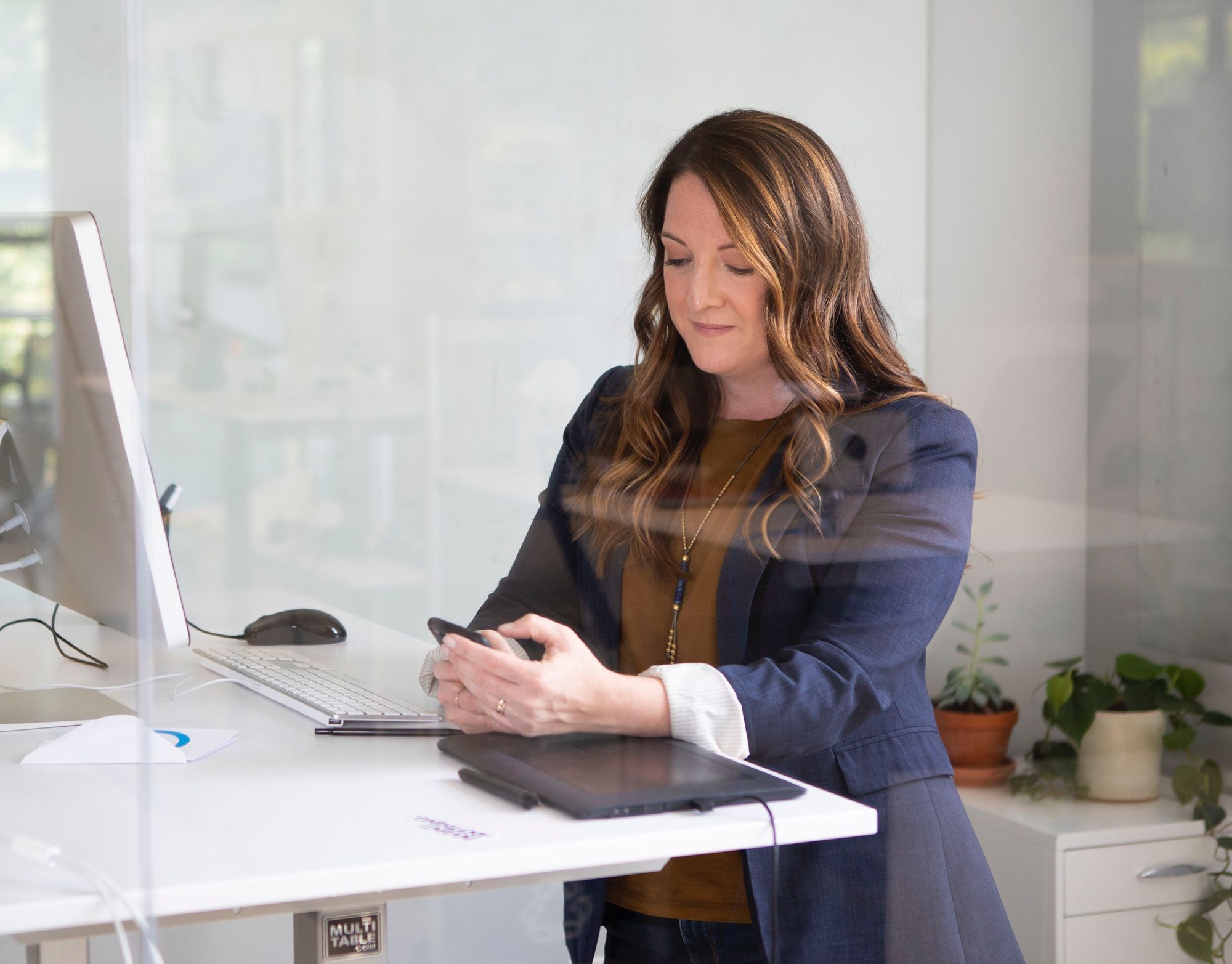 The marketing agency's manager works on her phone reviewing the online testimonials one of the agency's clients received.